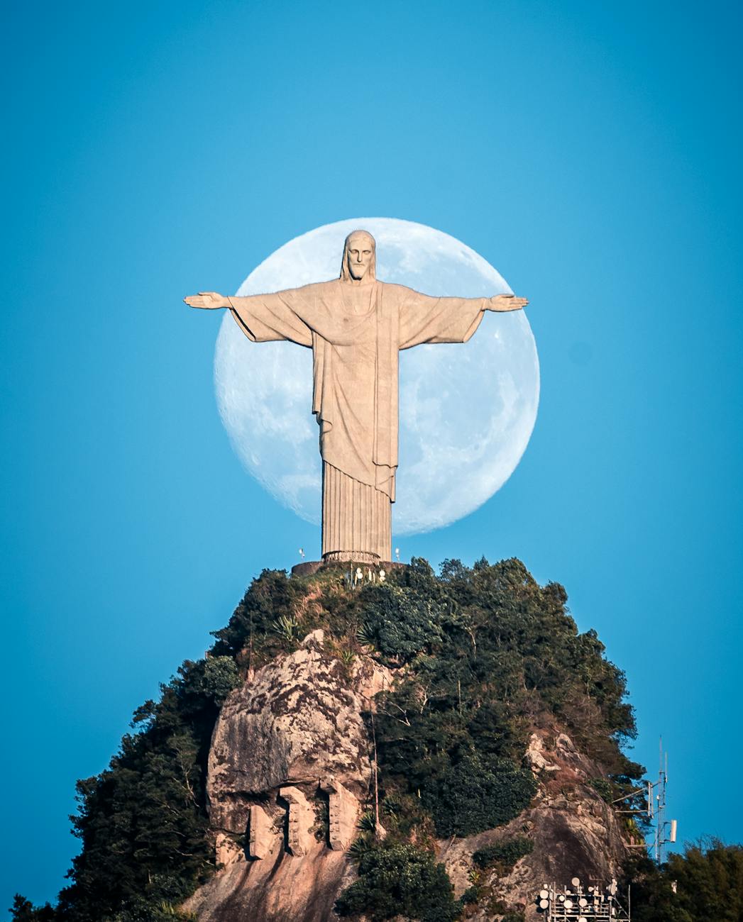 statue of jesus with the moon in the background